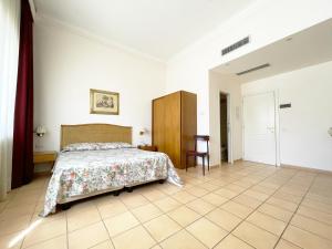 een slaapkamer met een bed en een stoel bij Hotel Reginella in SantʼAgata sui Due Golfi