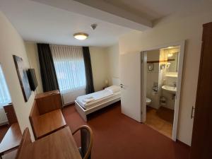 a room with a bathroom with a bed and a sink at Hotel Hennies Hannover Sehnde in Hannover