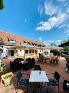 een patio met tafels, stoelen en parasols bij Georgenberg in Spremberg