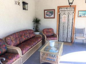 sala de estar con sofá, mesa y silla en Family House - La Mora Beach - Tarragona, en Tarragona