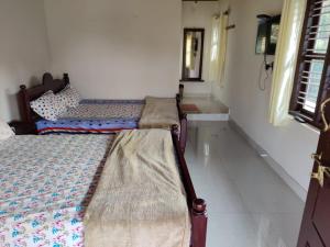two beds sitting in a room with a window at Creekside Cabin in Madikeri