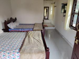 two beds sitting in a room with a window at Creekside Cabin in Madikeri +3 photos