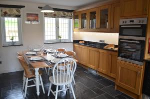 a kitchen with a table and chairs in a kitchen at The Cottage, Treliggon Farm in Lanivet