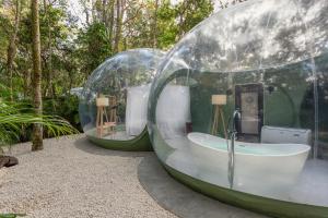 Duas cúpulas de vidro com uma banheira num jardim em Oom Bubble Boutique Riviera Cancun em Puerto Morelos