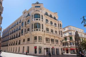 Un gran edificio blanco en una calle de la ciudad. en Malaga Center Flat Luxury, en Málaga