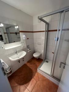 W łazience znajduje się prysznic, umywalka i toaleta. w obiekcie Hotel Hennies Hannover Sehnde w Hanowerze