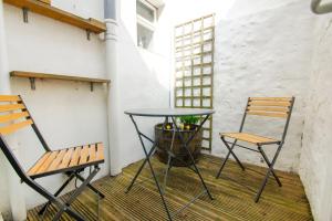 two chairs and a table on a balcony at Mermaid Cottage - Wood Burner- by Brighton Holiday Lets in Brighton & Hove