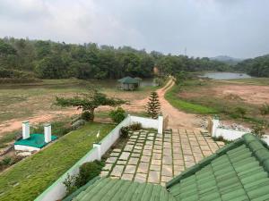 an aerial view of a house with a road and a field at Creekside Cabin in Madikeri