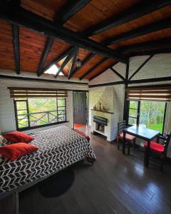 1 dormitorio con cama, mesa y chimenea en Estancia De La Campiña, en Nono