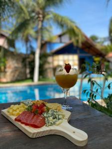 a plate of food and a drink on a table at Pousada Refúgio do Manatí in Canoa Quebrada