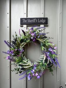 Una corona en una puerta con un cartel. en The Sheriffs Lodge, en Dingwall