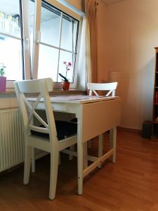 escritorio con 2 sillas y mesa con ventana en FeWo Lahnblick en Löhnberg