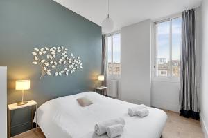 um quarto com 2 camas brancas e uma janela em L'APOLLINAIRE - à 5 minutes du centre ville em Toulouse
