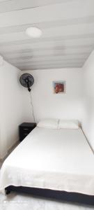 um quarto com uma cama branca e um tecto branco em Hermoso apartamento em Florencia