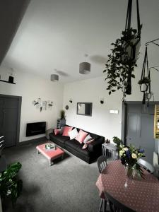 a living room with a black couch and a table at The Sheriffs Lodge in Dingwall