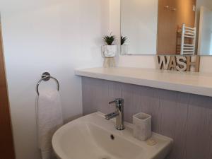 a bathroom with a sink and a mirror at Eastcliff Escape Folkestone in Folkestone