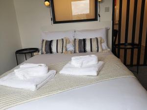 a bed with white towels on top of it at Eastcliff Escape Folkestone in Folkestone