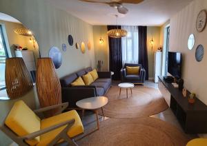 a living room with a couch and chairs and a tv at Les Cerisiers - Exclusive Beach Residence - 3 Bedroom Modern Apartment, Flic en Flac in Flic-en-Flac