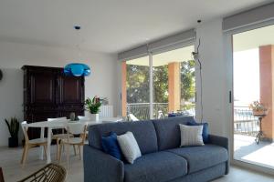 a living room with a blue couch and a table at CASA FIORENZA PRIVATE PARCHING CITRA 008055-LT-1530 in Sanremo