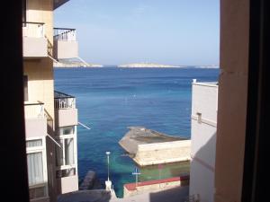 a view of the ocean from a building at The Sea just Across the Road - Flat 3 in St Paul's Bay