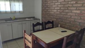 een keuken met een tafel en stoelen en een bakstenen muur bij Solar Del Valle in Zonda
