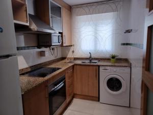 a kitchen with a sink and a washing machine at APCOSTAS Marina D'or 2da Línea in Oropesa del Mar