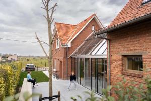 a house with a courtyard with people walking on the sidewalk at stek&stoof in Sint-Pauwels