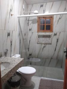 a bathroom with a shower and a toilet and a sink at Pouso do Bizuca in Tiradentes