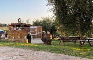 una zona de picnic con mesas de picnic y un edificio en FATTORIA ROVELLO en San Paolo di Civitate
