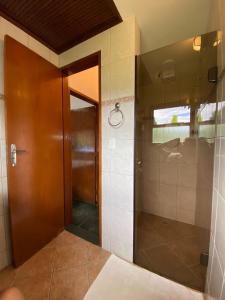 a bathroom with a shower and a glass door at Casa Vento Norte in Ilhabela