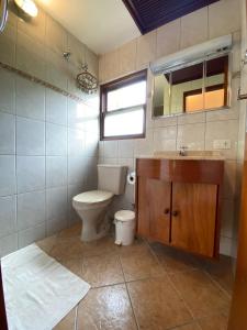 a bathroom with a toilet and a sink and a mirror at Casa Vento Norte in Ilhabela