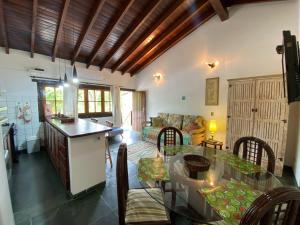 a kitchen and a living room with a table and chairs at Casa Vento Norte in Ilhabela