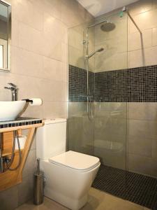 a bathroom with a toilet and a glass shower at Casa Rainbow - Boutique Bed & Breakfast in Mojácar