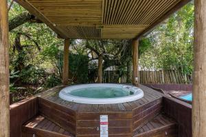 bañera de hidromasaje en una terraza de madera con pérgola en Apto pé na areia com vista p/ mar JBM, en Florianópolis