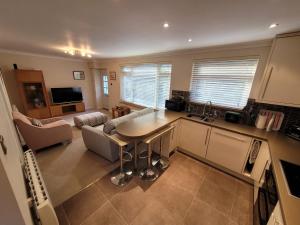 a kitchen and living room with a table and a couch at Captivating 2 bedroom bungalow in mumbles in Swansea