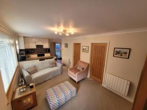 a living room with a couch and a chair at Captivating 2 bedroom bungalow in mumbles in Swansea