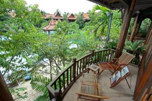ein Außenbalkon mit zwei Stühlen und Bäumen in der Unterkunft Sokhalay Angkor Villa Resort in Siem Reap