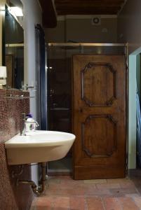 a bathroom with a sink and a wooden door at Appartamento Baldo 13 in Perugia