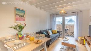 ein Wohnzimmer mit einem Sofa und einem Tisch in der Unterkunft Appartement Duplex proche Port avec vélos in Vannes