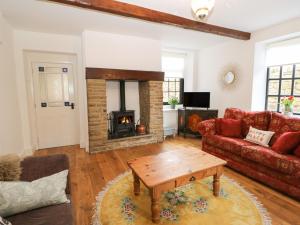 a living room with a couch and a fireplace at The Cottage in Barnsley