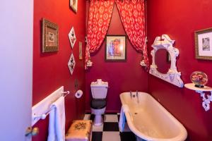 a red bathroom with a tub and a sink at La Rosa Hotel in Whitby