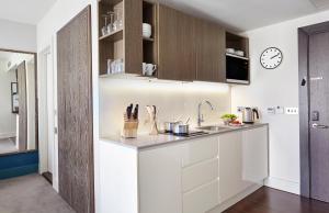 a kitchen with white cabinets and a sink at Staybridge Suites London-Vauxhall, an IHG Hotel in London