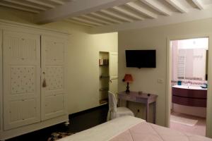 a bedroom with a bed and a desk and a tv at B&B LA CHIMERA in Arezzo