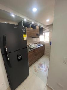 una cucina con frigorifero nero in camera di Apartamento de Henry y Rita a Barranquilla