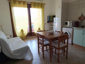 a kitchen with a table and a bed and a table and chairs at Casa Deidda in Villaputzu