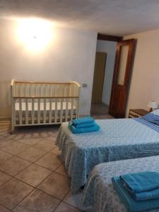 a bedroom with two beds with blue towels on them at Casa Deidda in Villaputzu