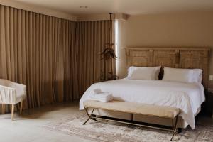 グアタペにあるTau Houseのベッドルーム(大きな白いベッド1台、椅子付)