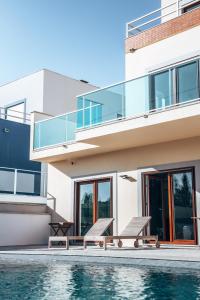 a house with a swimming pool next to a house at Wellnesshouse in Atouguia da Baleia