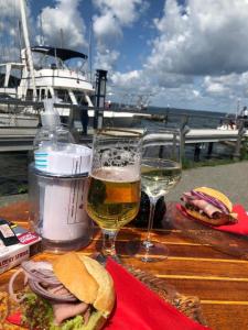 a table with two glasses of beer and a sandwich at Ferienwohnung "Leevhuus" in Glücksburg