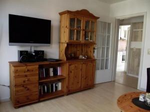 a wooden entertainment center with a television on top of it at Fliegender Holländer in Juist